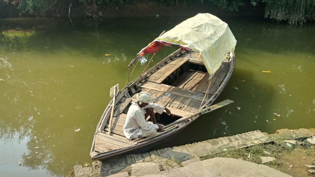 A boatman awaits some pilgrims for a joyride in the lake