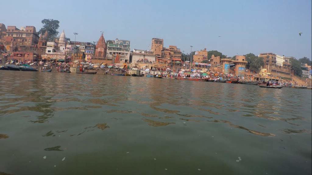 The river is packed with boats carrying tourists watching the arati