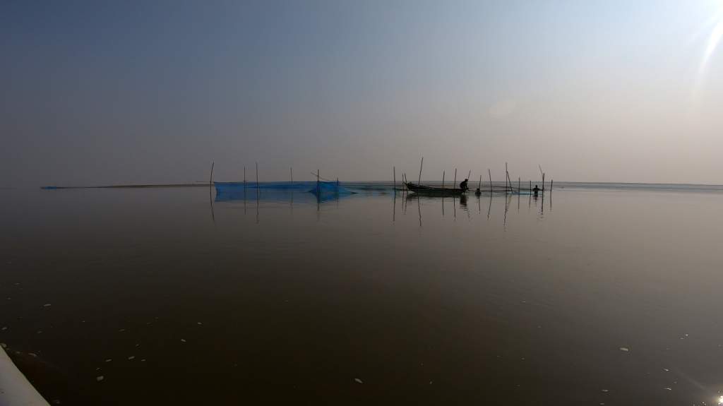 Couple of fishermen fixing their nets